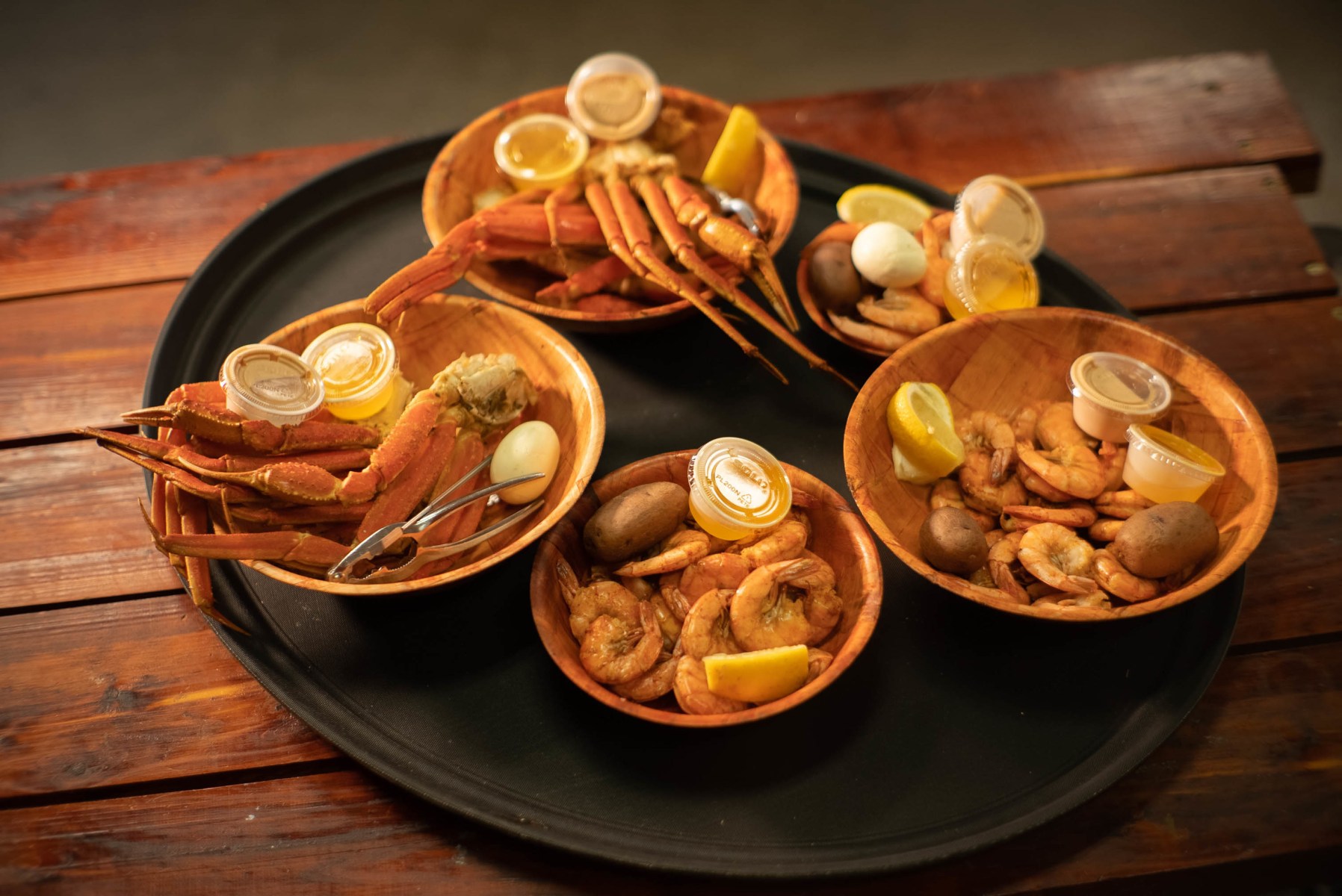 Boiled crab legs, shrimp and sides served in wooden bowls at Crawfish Getaway
