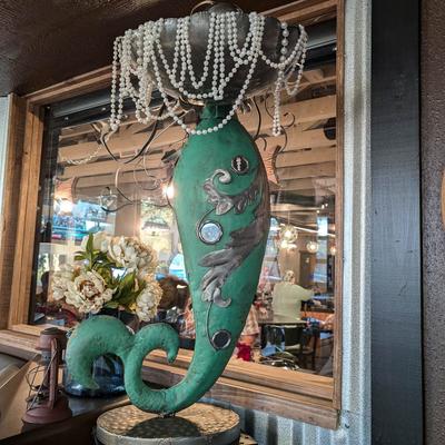 Mermaid figure dressed in pearls by the window